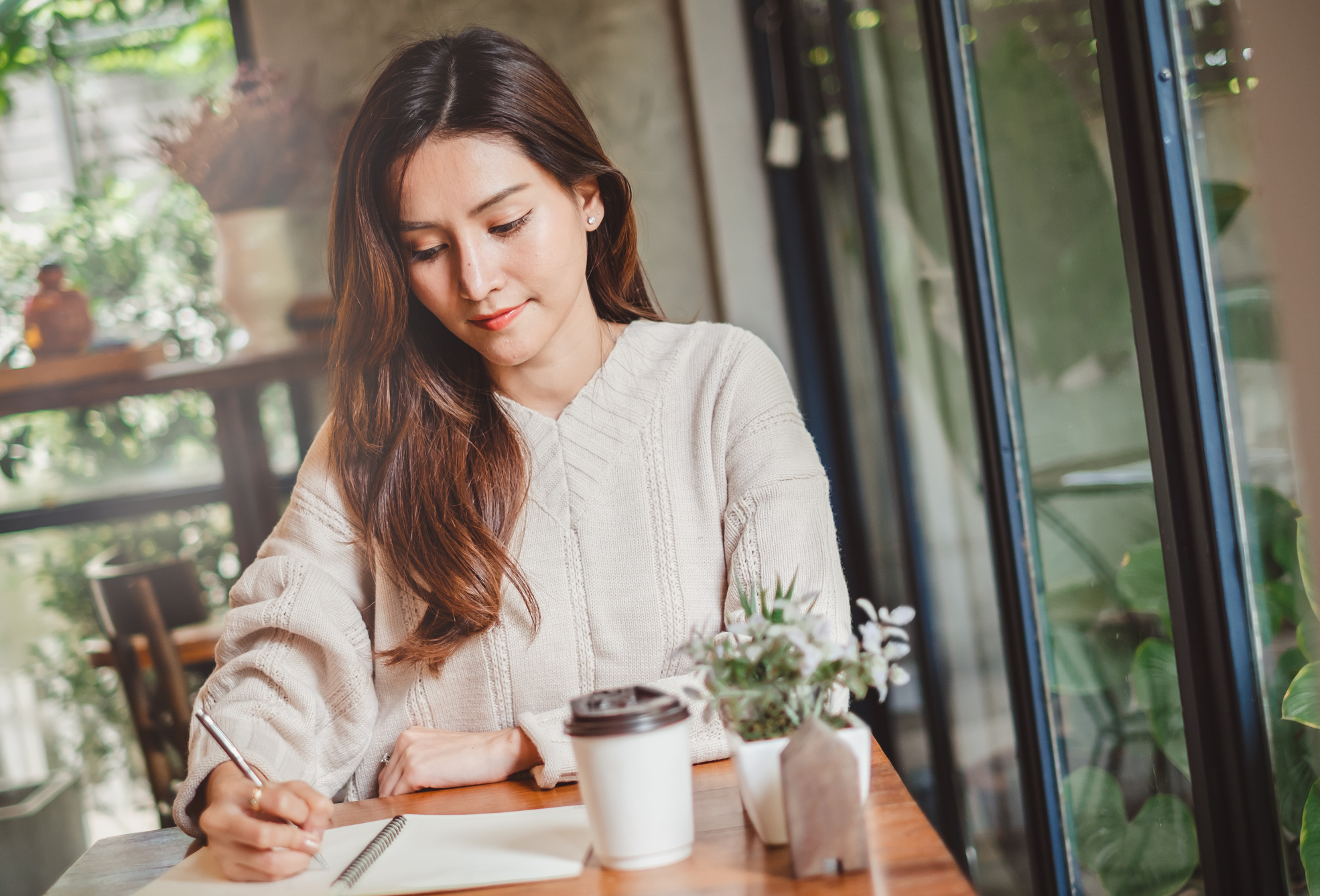 Close up Asian woman hand writing on notebook